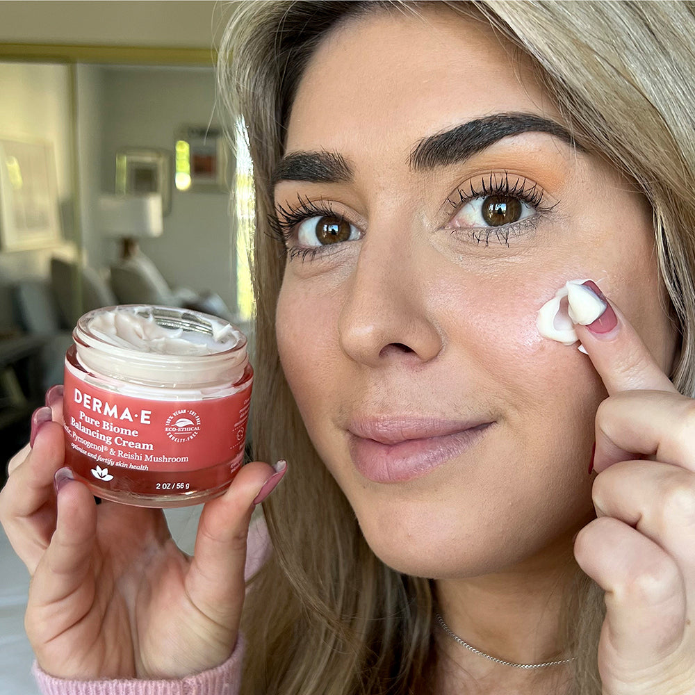 Woman holding a jar of Pure Biome Balancing Cream
