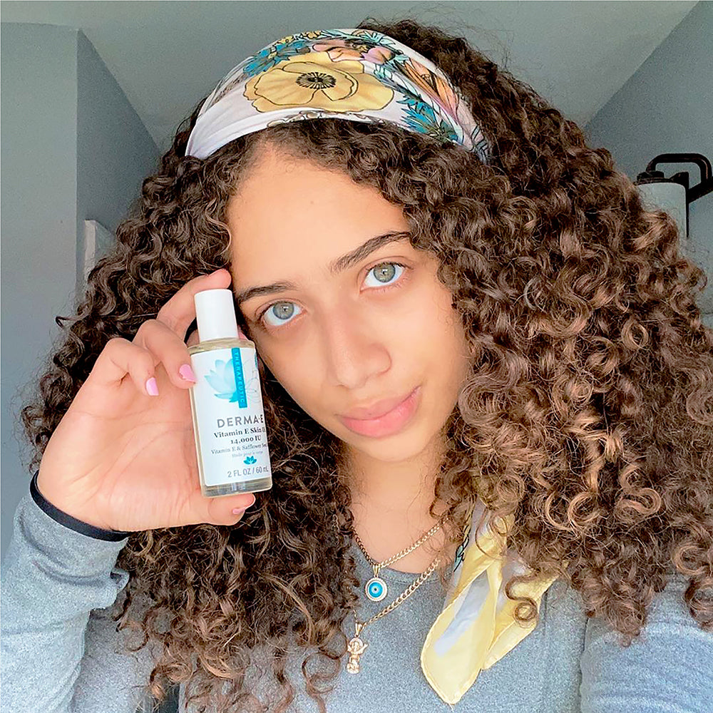 Woman holding a bottle of Vitamin E Oil for Skin - DERMA E Clean Skin Care