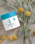Jar of Eczema Relief Cream on a table with flowers