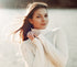 Brunette woman smiling in a white turtleneck sweater in winter