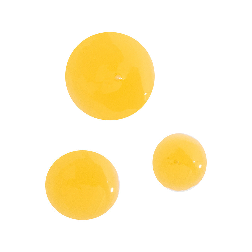 Close-up of three golden drops of Vitamin C product, highlighting its rich and nourishing texture.