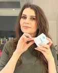 Woman holding a bottle of Derma E Vitamin E Cream 12,000 I.U.