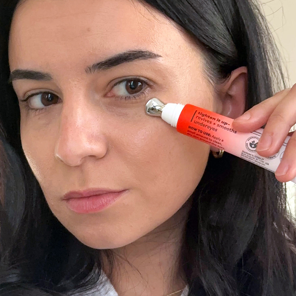 Woman applying a skincare product to her face with a tube in close-up