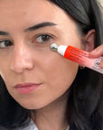 Woman applying a skincare product to her face with a tube in close-up