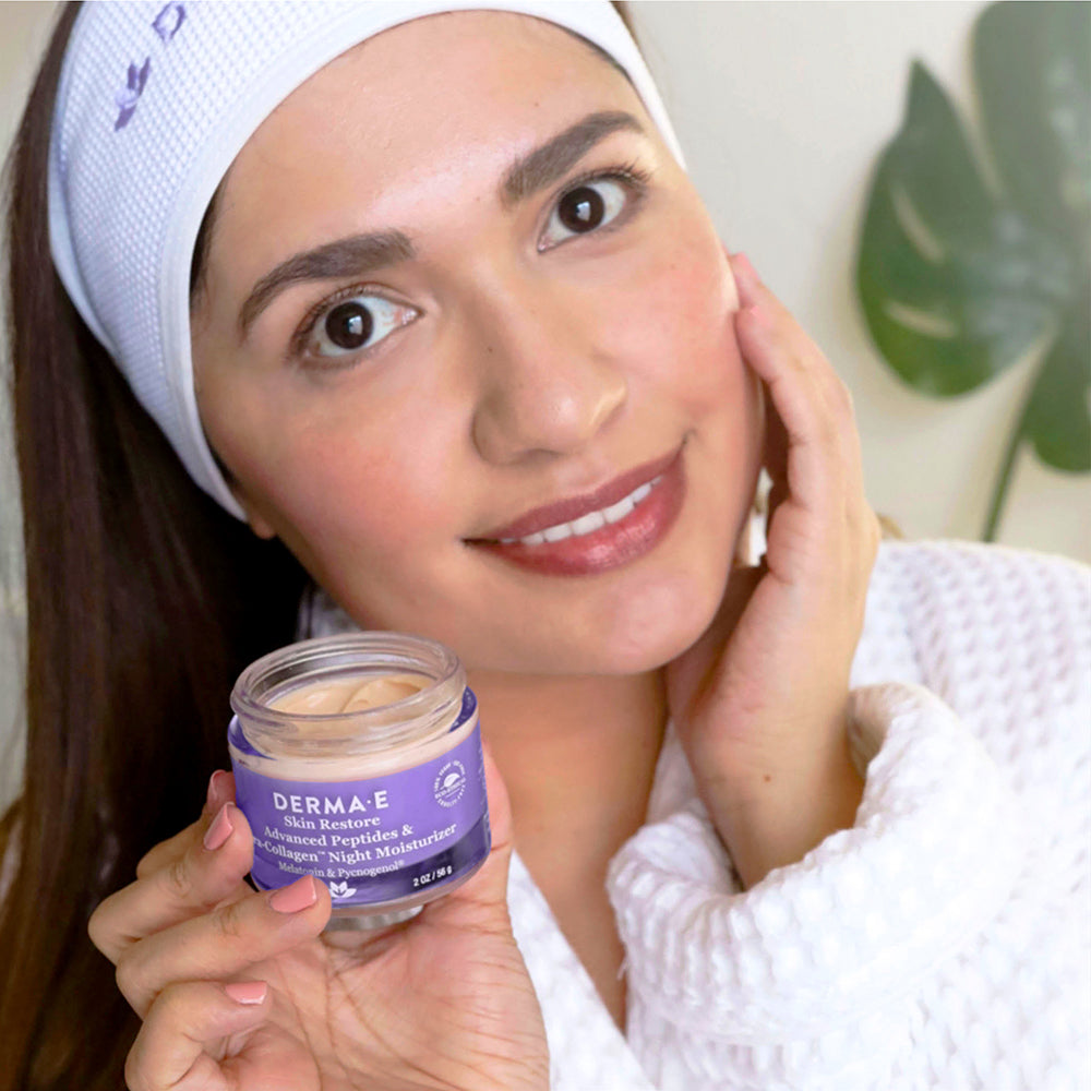 Woman applying Advanced Peptides &amp; Flora-Collagen™ Night Moisturizer to her face, demonstrating its smooth, creamy texture and easy absorption.