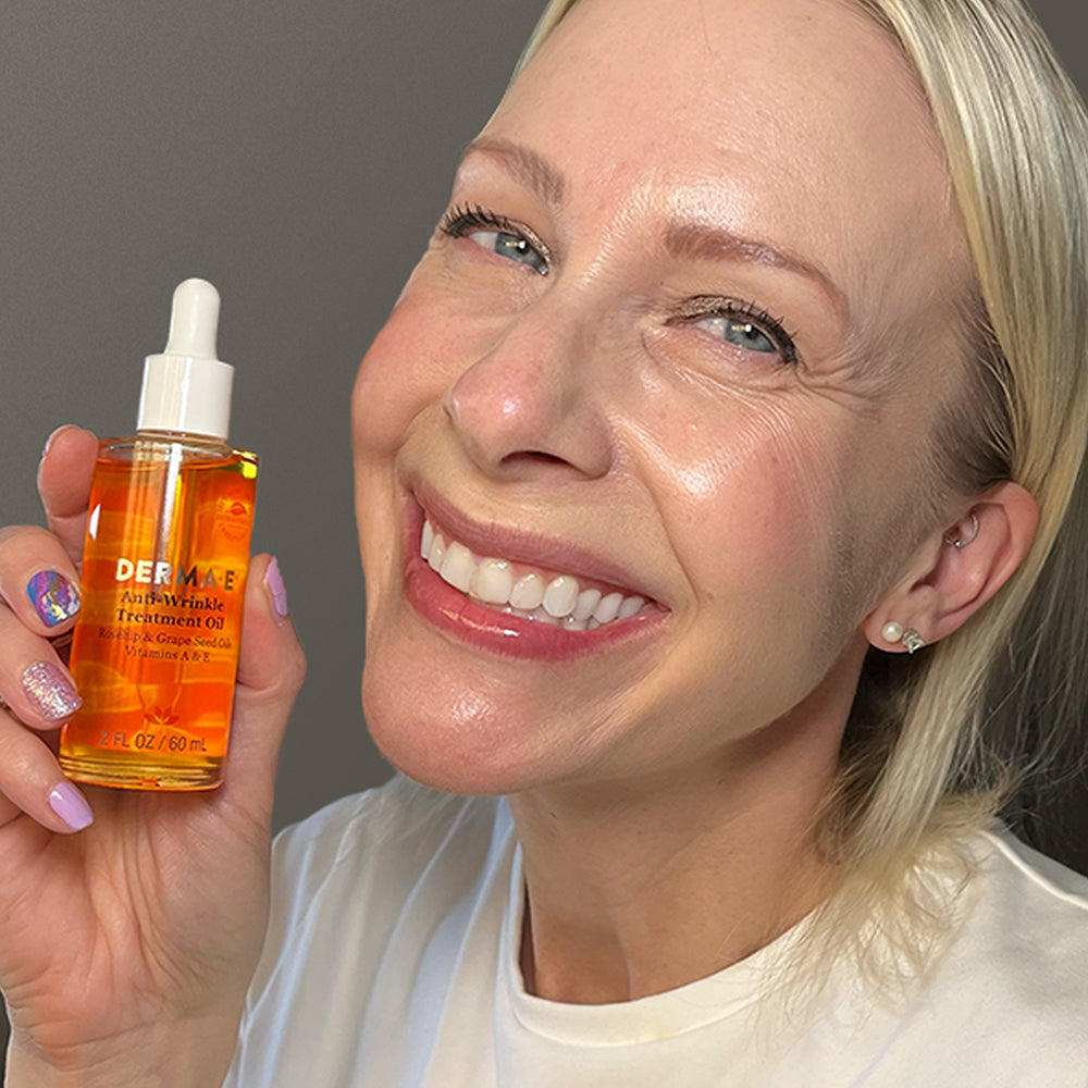 Woman holding Derma E Anti-Wrinkle Treatment Oil, highlighting its benefits for reducing fine lines.