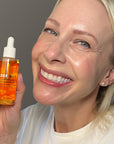 Woman holding Derma E Anti-Wrinkle Treatment Oil, highlighting its benefits for reducing fine lines.